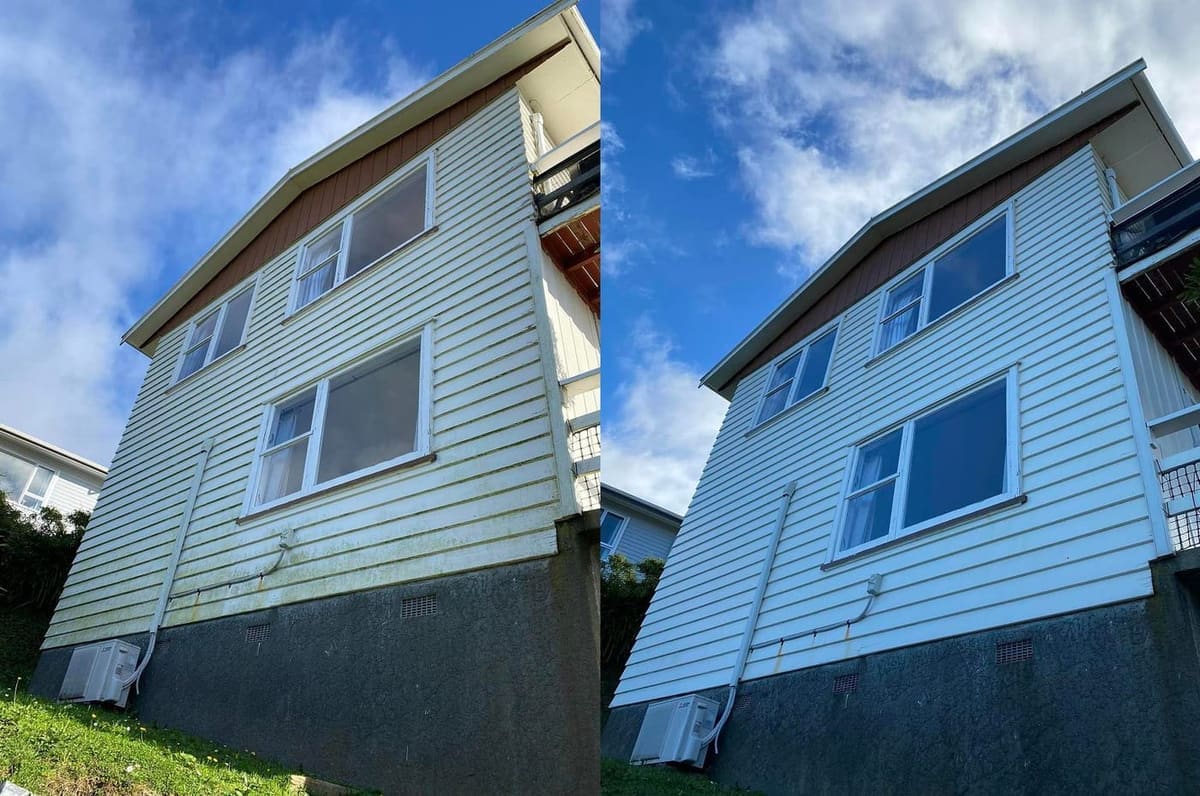 Wellington house wash before and after, hillside two-storey weatherboard home with heavy green algae across the cream cladding before, clean bright white weatherboard after a soft-wash with biocide chemistry